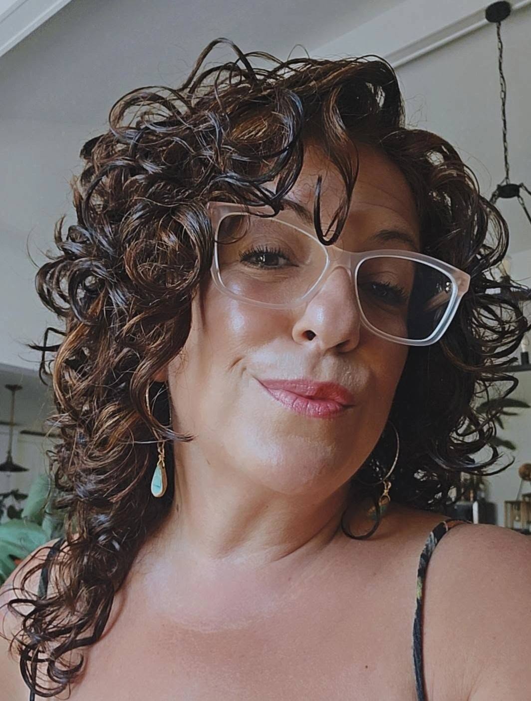 A curly-haired client showing off her beautifully defined curls after a DevaCurl service.