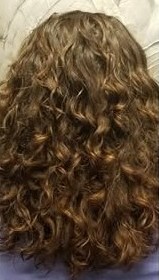 A stylist applies professional hair color to a client in a salon setting