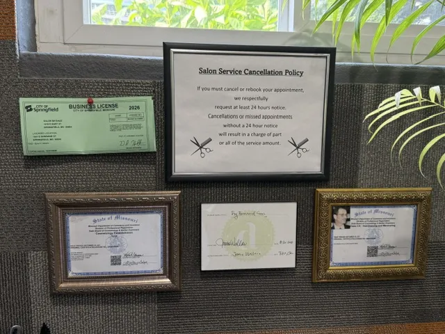 Salon service cancellation policy and various certificates displayed on a wall.